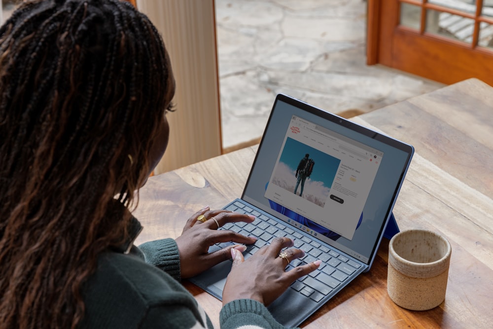 Eine Frau sitzt an einem Tisch mit einem Laptop