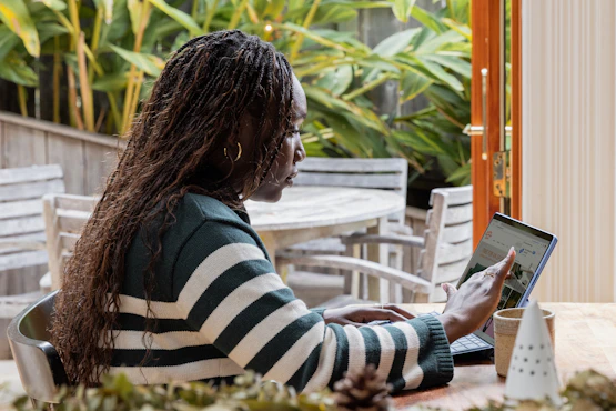 Business owner reviewing a page on a laptop screen at an outdoor table