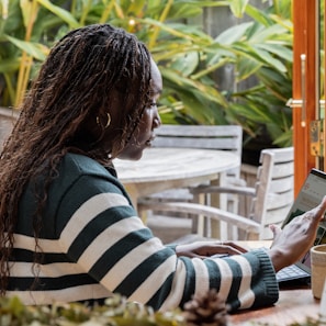 a person standing in front of a laptop computer talking on a cell phone