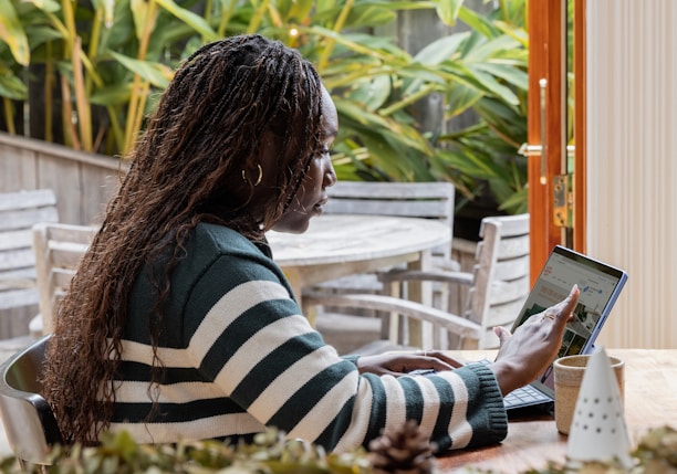 a person standing in front of a laptop computer talking on a cell phone