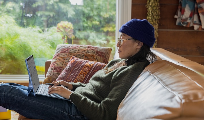 a person sitting at a table using a laptop