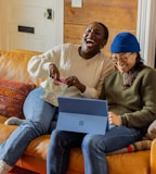 a person sitting on a couch with a laptop