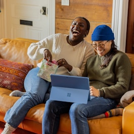 a person sitting on a couch with a laptop