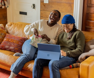 a person sitting on a couch with a laptop