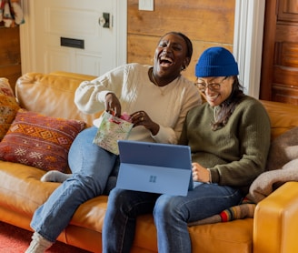 a person sitting on a couch with a laptop