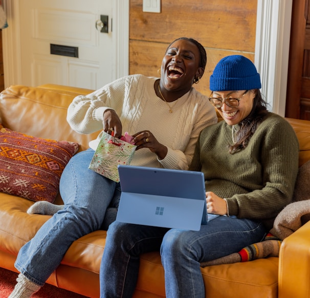 a person sitting on a couch with a laptop