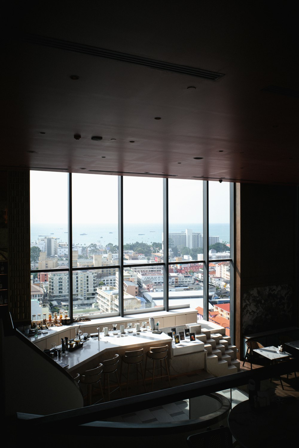a room with a large window and a table with chairs and a view of a city