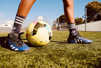 a person's legs and feet on a football ball