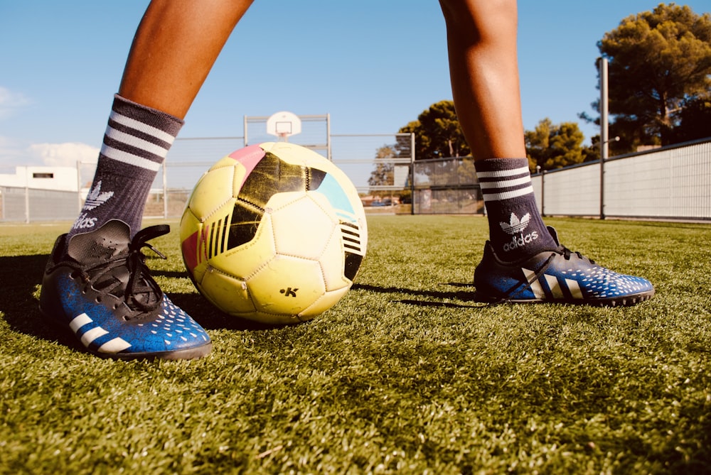 a person's legs and feet on a football ball