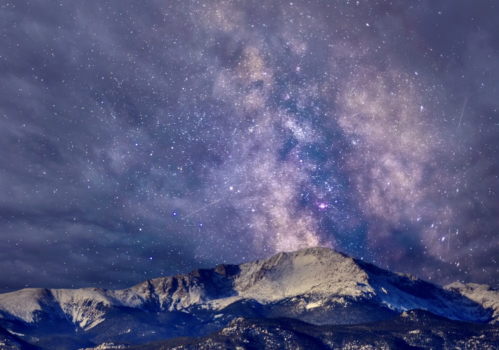 a snowy mountain with stars in the sky