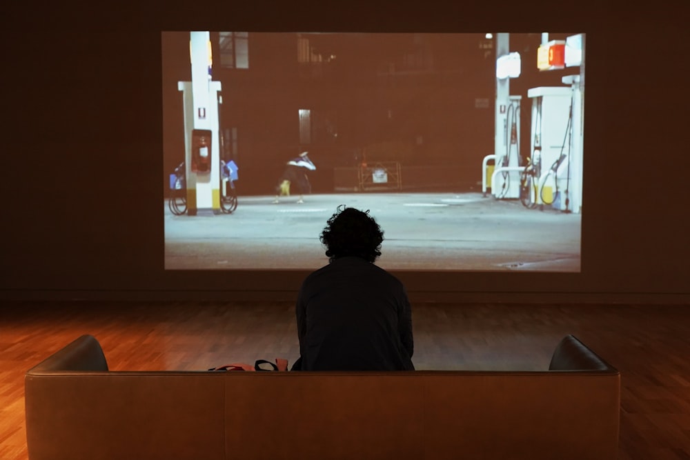 a person sitting in front of a large screen