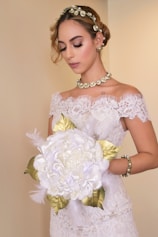 a woman in a wedding dress holding a bouquet of flowers