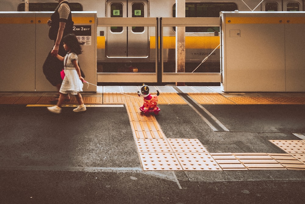 a person and a child walking on a train platform