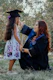 a woman in a graduation gown and cap next to a girl in a dress