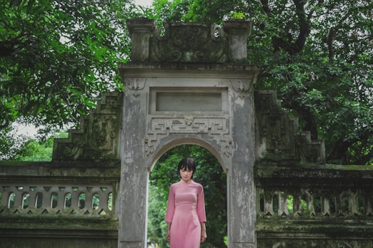 a person standing in front of a large stone arch