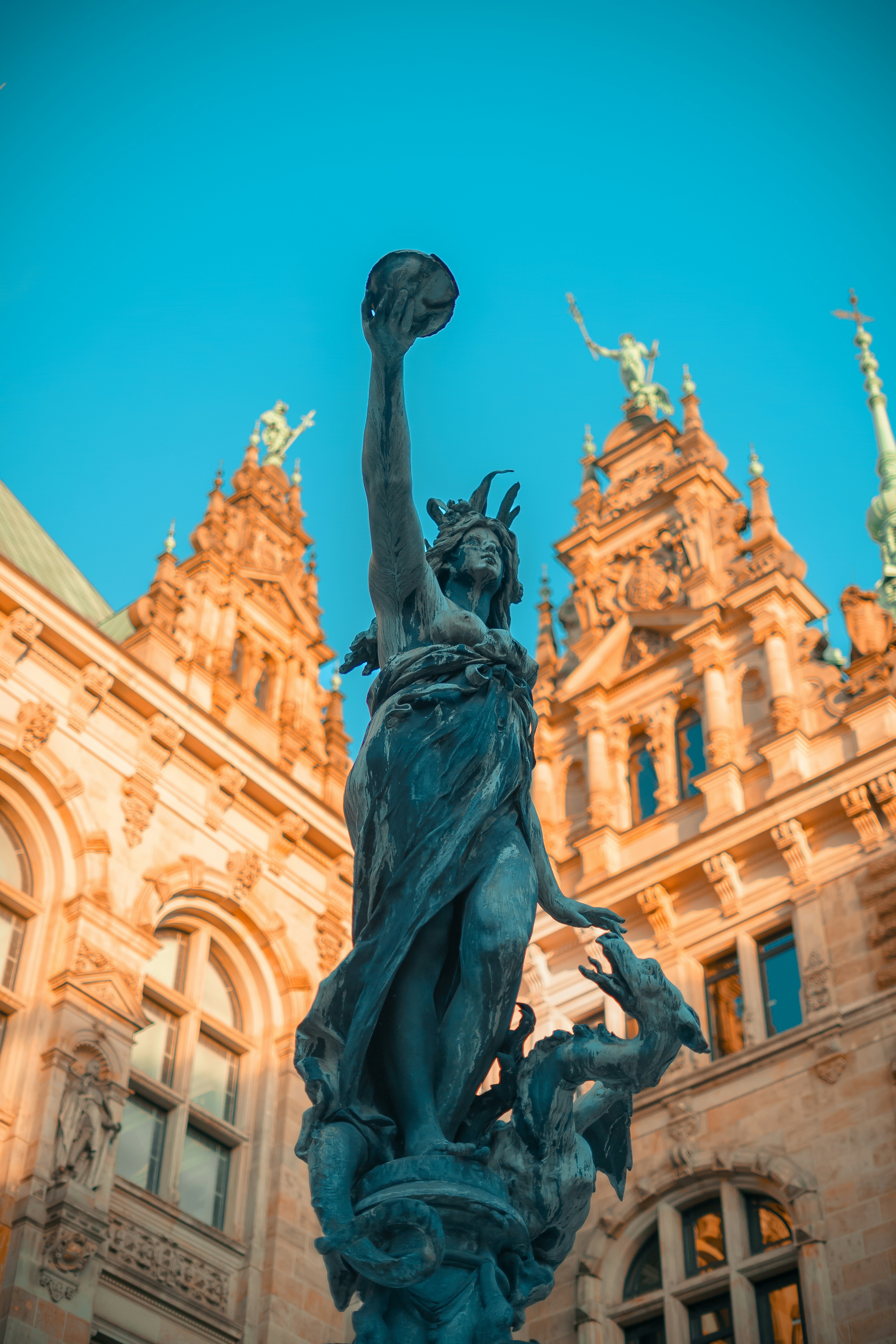 a statue of a person holding a torch in front of a building