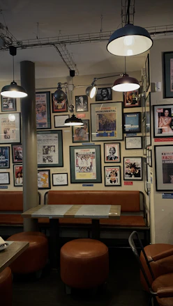 Cozy shop interior showing framed artwork and memorabilia on display walls.