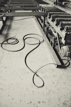 Close-up image of a thick, green industrial cable coiled neatly in a factory setting