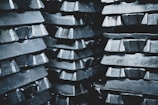 Close-up of heavy metal ingots stacked neatly in a warehouse.