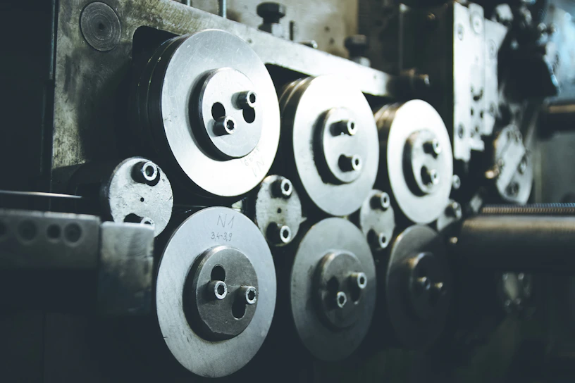 Close-up of industrial bearings and mechanical parts arranged on a metallic surface with warm lighting.