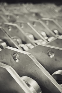 Monochrome image showing stacked steel plates with textured surfaces.