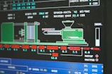 A computer screen displaying a graphical interface with technical information, possibly related to manufacturing or machinery operation. The interface includes a diagram of an industrial machine, text in Cyrillic script, and various numerical data.