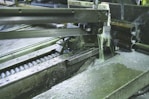 Industrial machine in action with cutting tools installed, showing metal being machined.