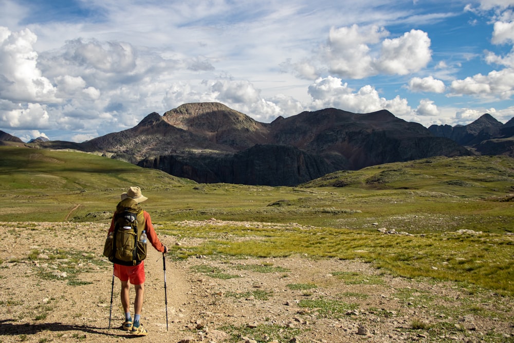 a person walking on a trail with mountains in the background