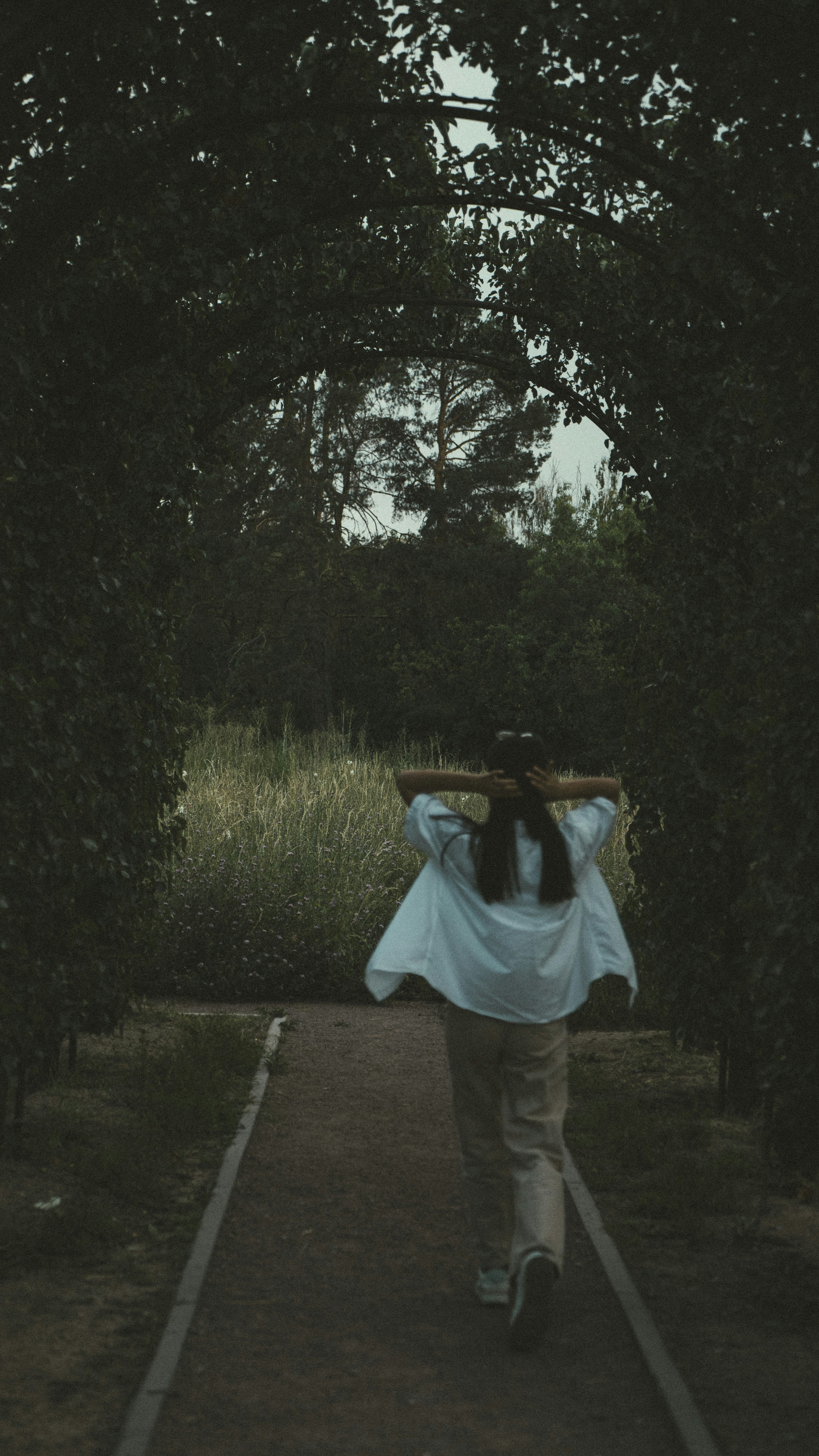 a person walking down a path with a blue bag over their head