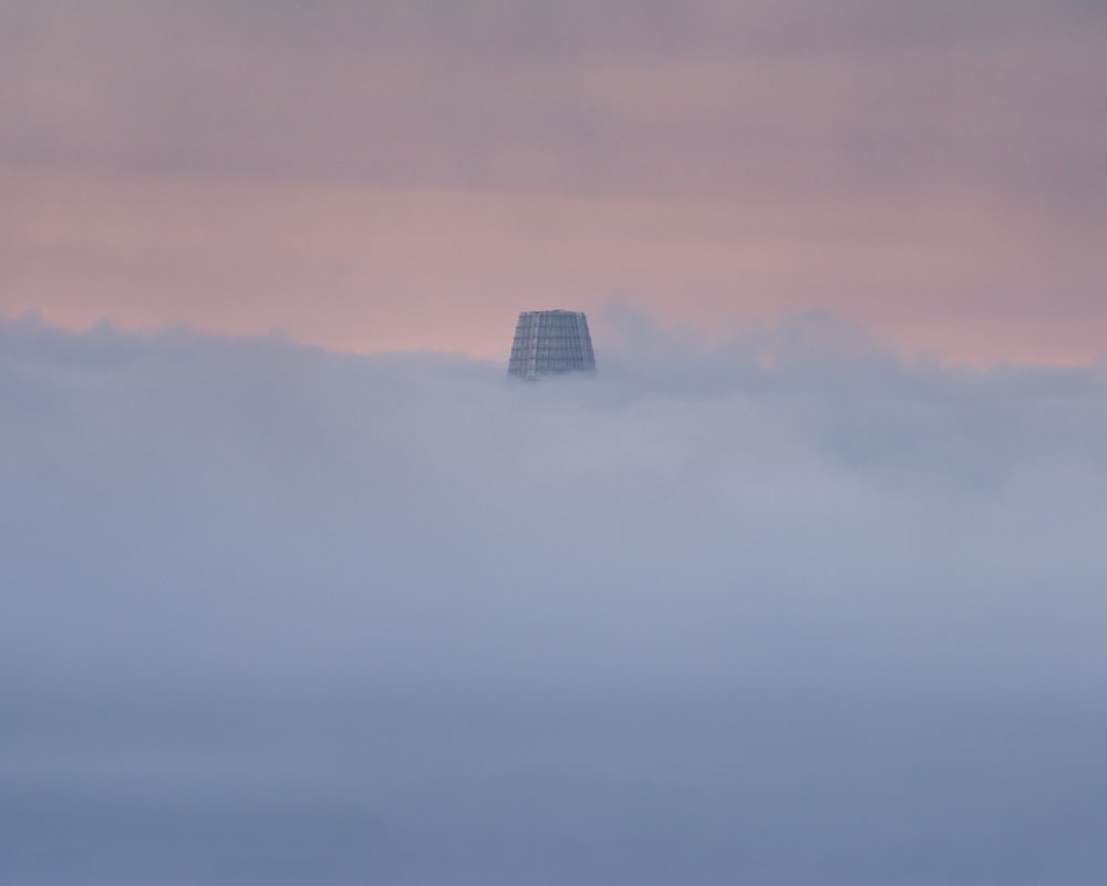 a building in the middle of a foggy landscape