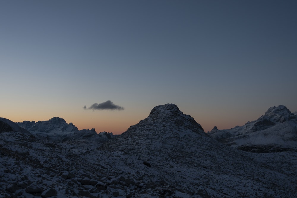 a rocky mountain with a cloudy sky