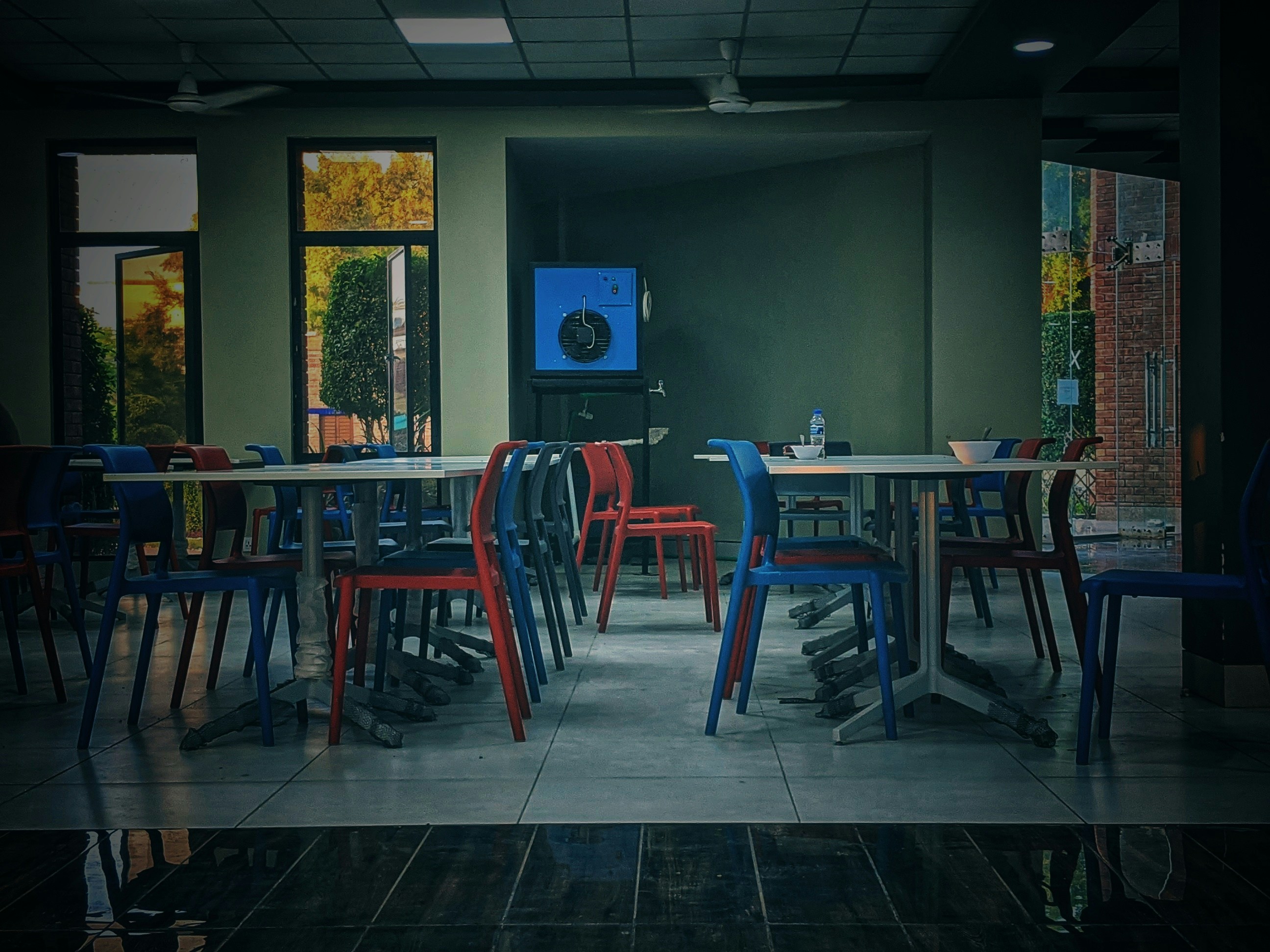 Bright modern cafeteria interior, tables and chairs, well-lit, clean environment