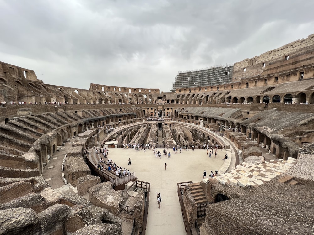 un gran edificio antiguo con gente caminando con el Coliseo al fondo