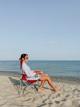 a person sitting in a chair on a beach