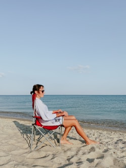 a person sitting in a chair on a beach