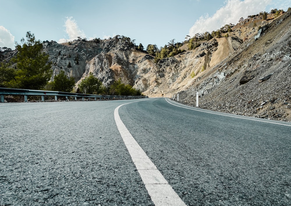 a road with a bridge over it and a rocky mountain in the background