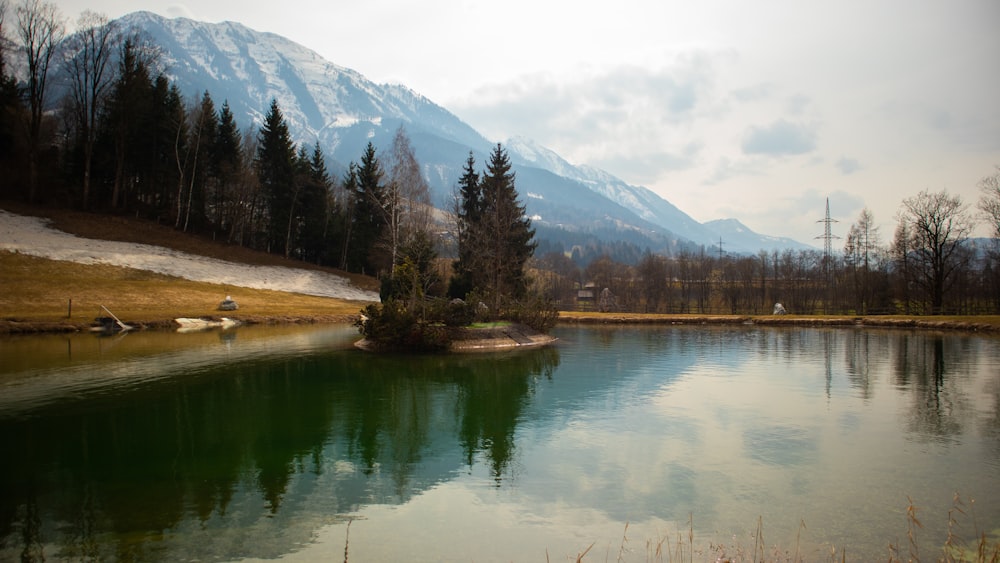 a lake with trees and mountains in the background