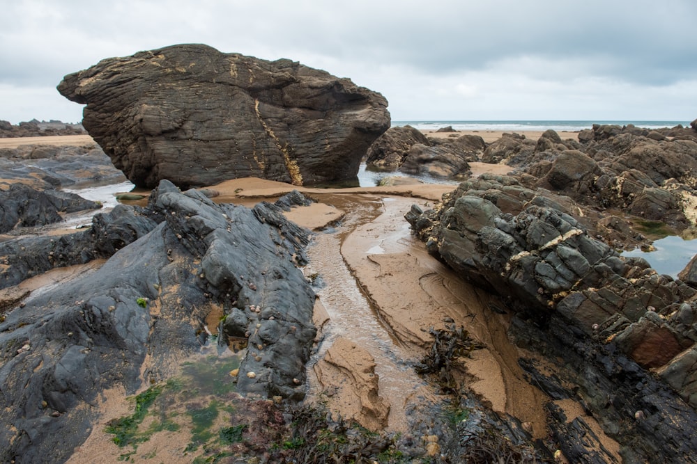 a rocky beach with a large rock formation