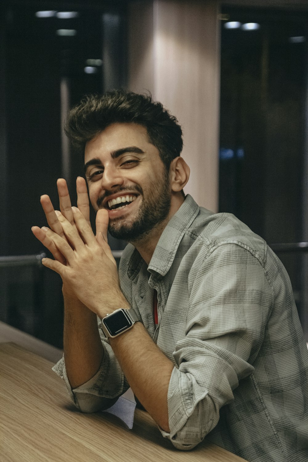 a man smiling and holding his hands up