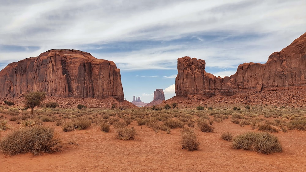 a desert landscape with tall rocks with Arches National Park in the background