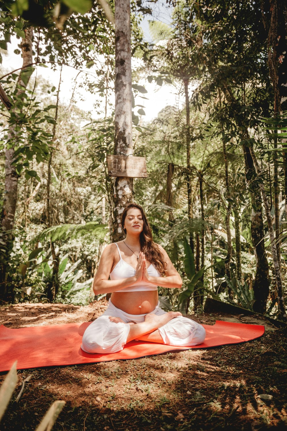 a person sitting on a mat in a forest