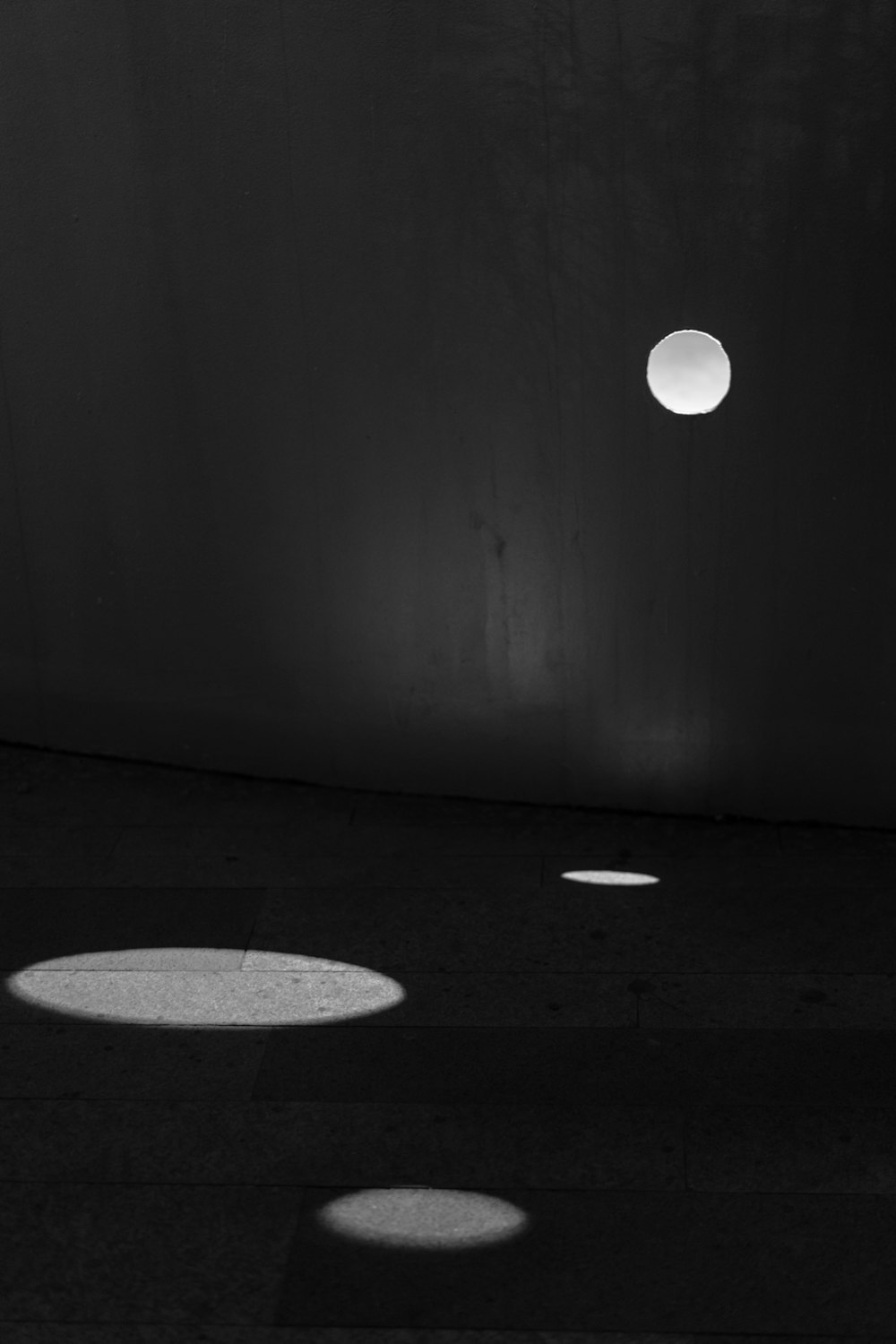 a black and white photo of a light on a wall