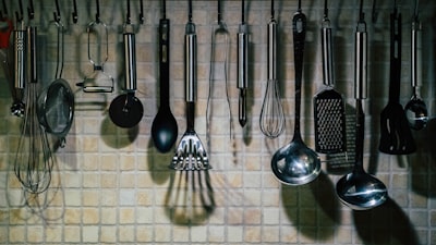 Whisks, ladles, and kitchen utensils hanging on a rack