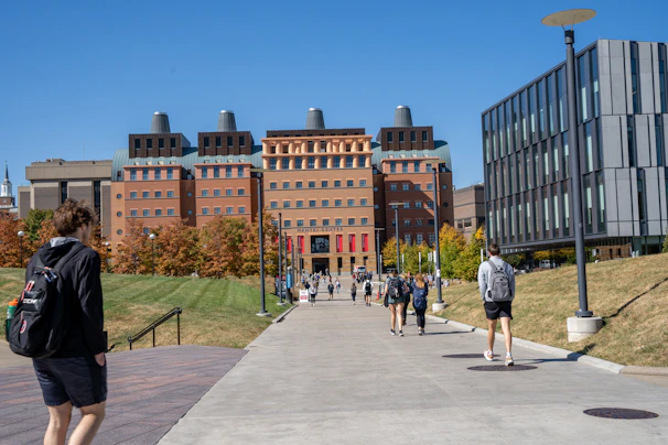 A diverse group of African students walking on an international campus pathway.