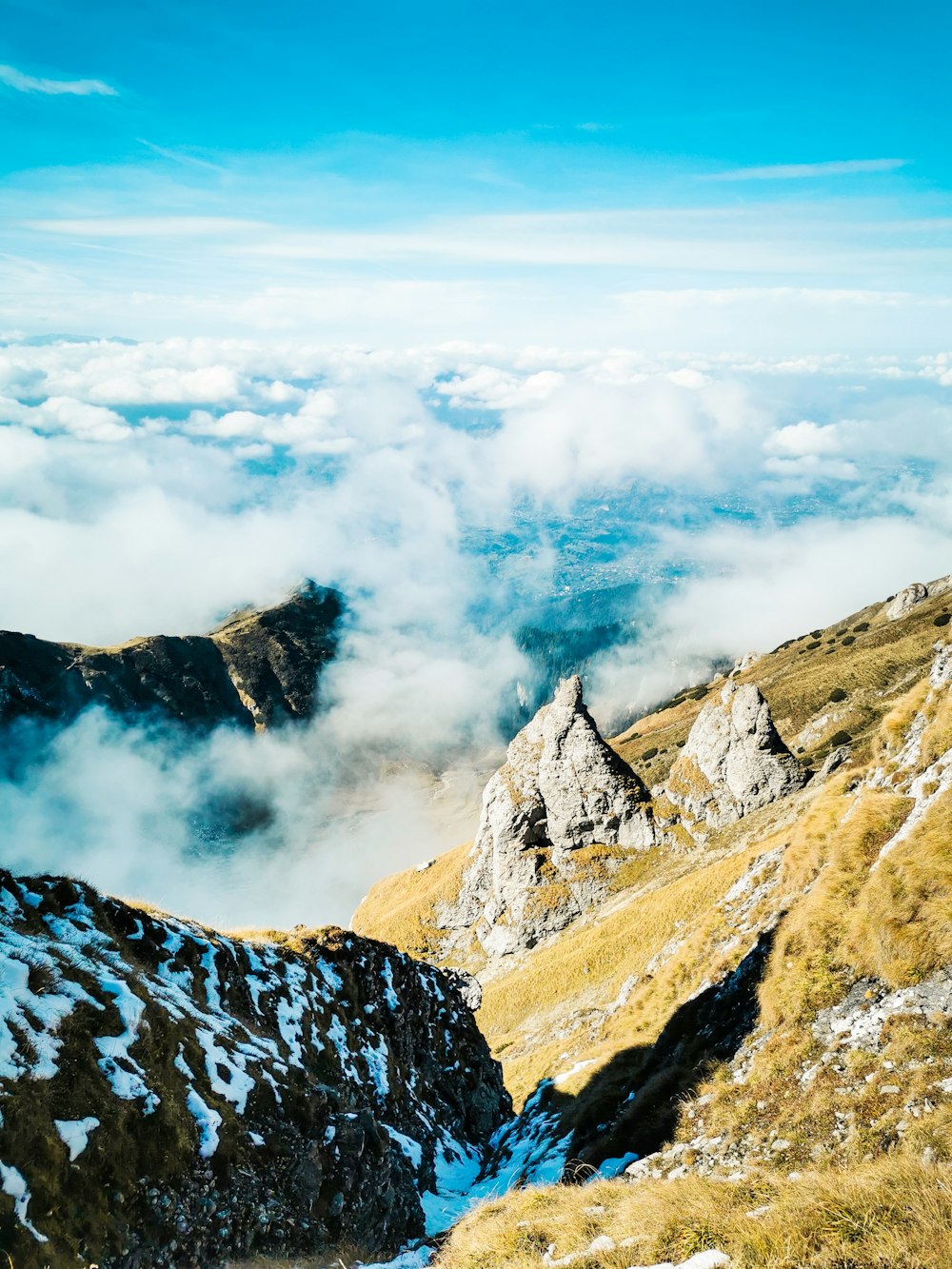 a mountain with clouds below