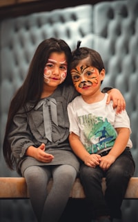 Two children, one Indian and one American, painting together on a large canvas.