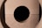 Circular cutouts in light wood create a symmetrical pattern with a dark void in the center.