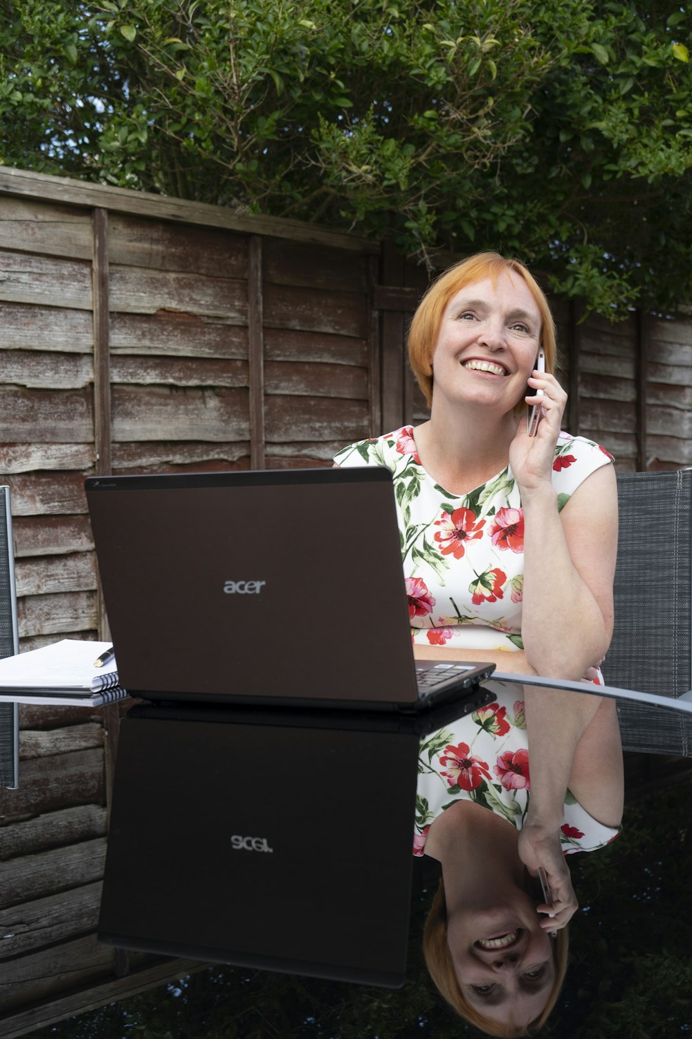 a person on a cell phone next to a laptop