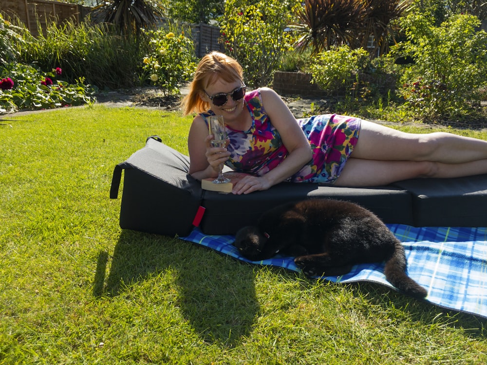 a person lying on a blanket with a cat on the lap