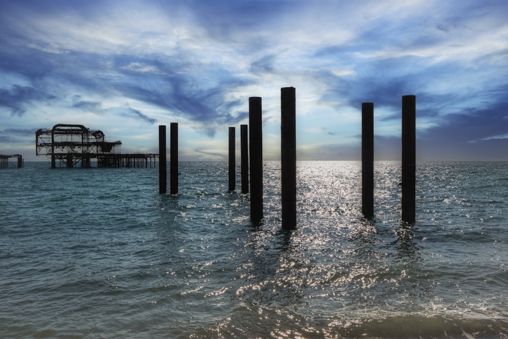 a group of wooden pillars in the water